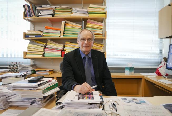 Prof. John Joannopulos, seated at the desk in his office. Photo: Jose-Luis Olivares, MIT 