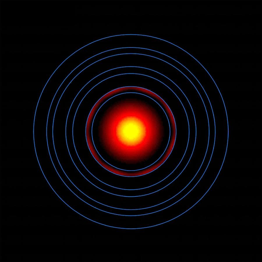 In the center of a black field are several concentric rings. The innermost ring holds a circle that is bright yellow in the center and fades to a deep red toward the outer edge. The next ring out contains a faint gradient of dark red fading into black.