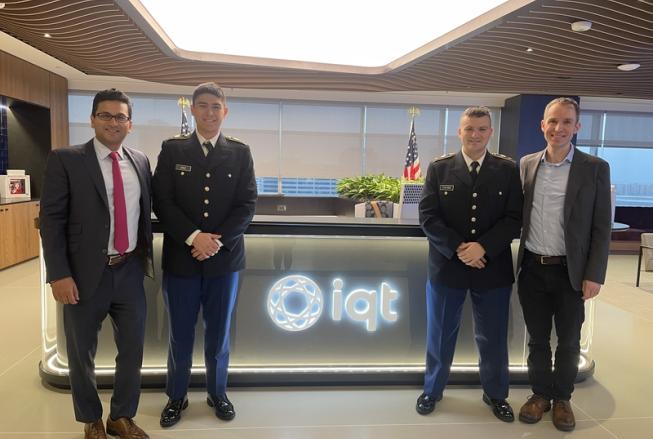 Four men, two in military uniforms, pose together