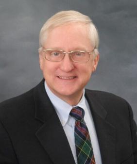 Prof. Olson in front of a grey background