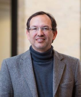 Prof. Alfredo Alexander-Katz stands in front of doors and windows